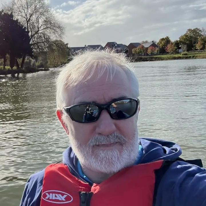 Keith Bennett driving an orange safety boat at WWYSA sailing event on a lake